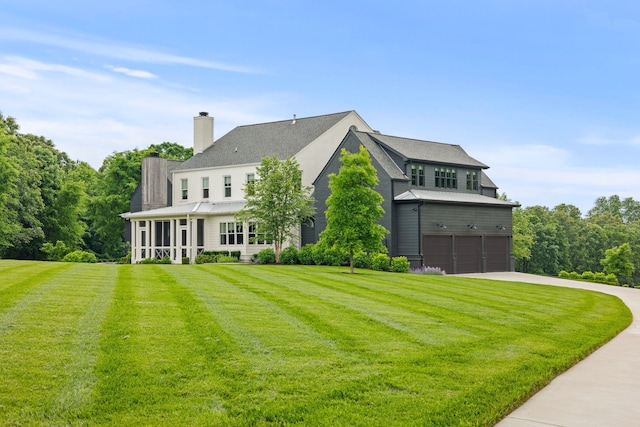 rear view of house with a garage and a lawn