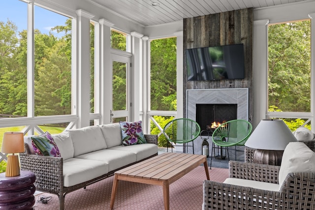 sunroom with a high end fireplace and wooden ceiling