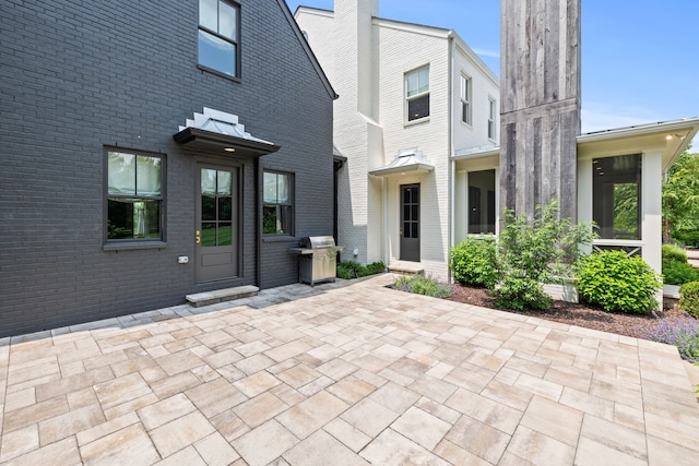 view of exterior entry with a patio