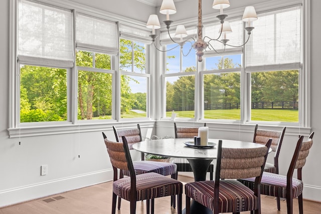 sunroom featuring a wealth of natural light and a notable chandelier