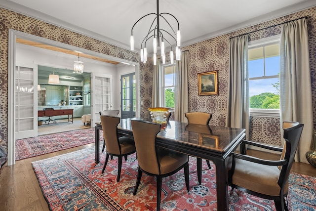 dining room featuring hardwood / wood-style floors, a notable chandelier, french doors, and ornamental molding