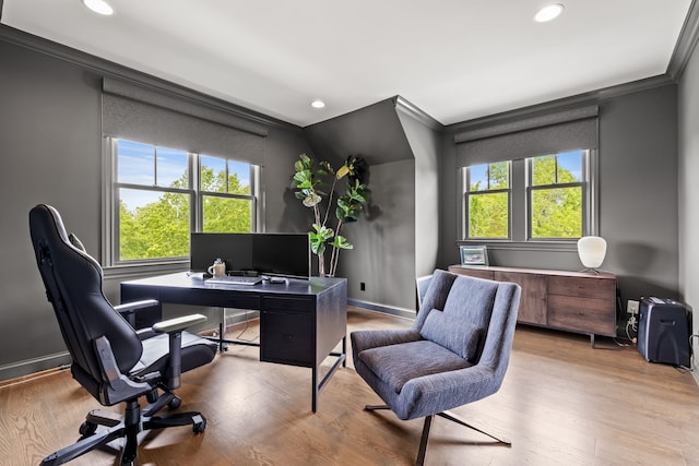 office area with light wood-type flooring and ornamental molding