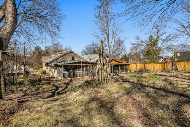 back of property featuring fence and a sunroom