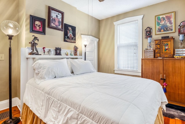 bedroom with wood finished floors and baseboards