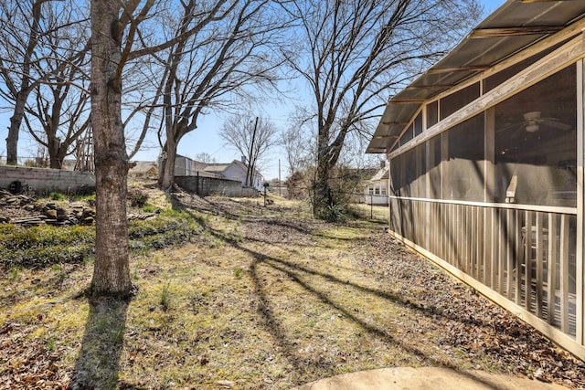 view of yard featuring fence and a sunroom