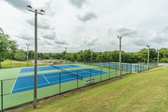 view of sport court with a yard and fence
