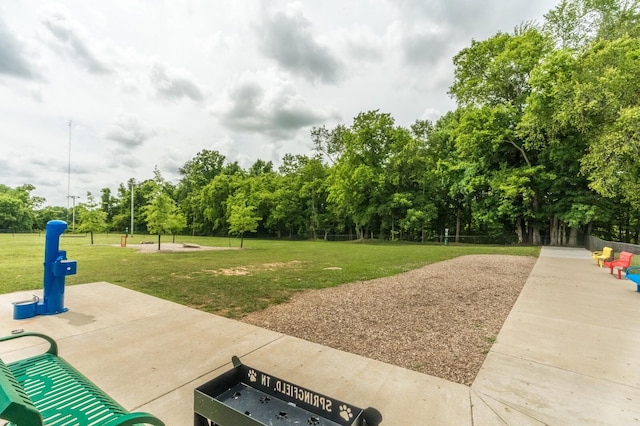 view of property's community featuring a lawn and a patio area