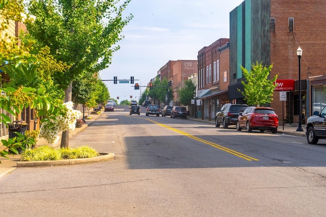 view of road with curbs, street lights, traffic lights, and sidewalks