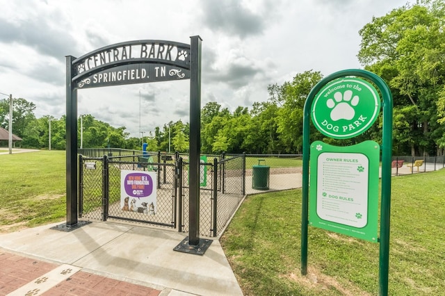 view of community with a gate, a yard, and fence