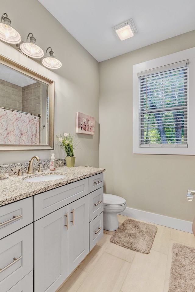 bathroom with toilet, vanity, tile patterned flooring, and curtained shower