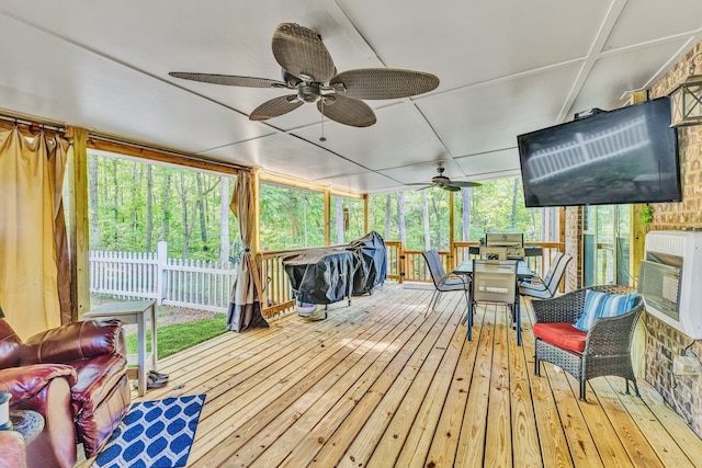 sunroom with ceiling fan, a healthy amount of sunlight, and heating unit