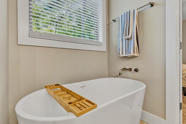 bathroom featuring a bathtub and a wealth of natural light