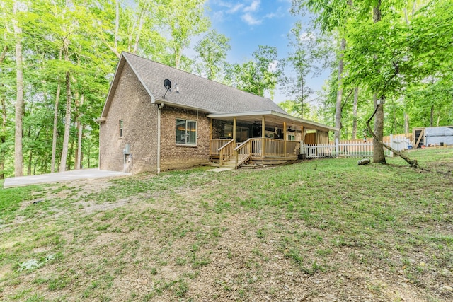 back of house featuring a lawn and a wooden deck