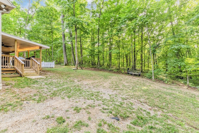 view of yard featuring ceiling fan and a wooden deck