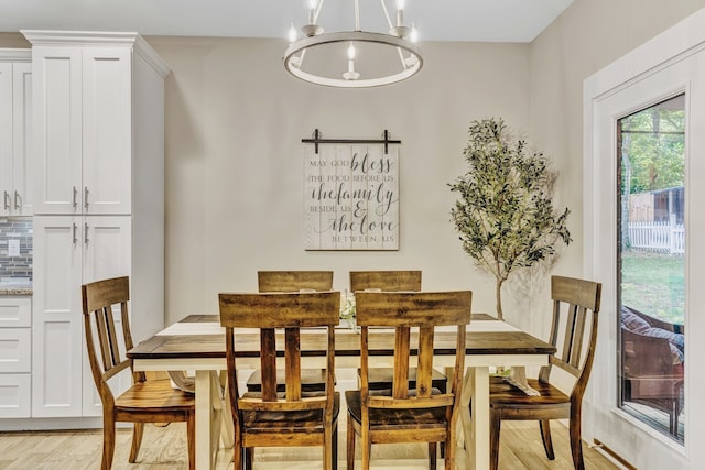 dining room with light hardwood / wood-style flooring and a notable chandelier