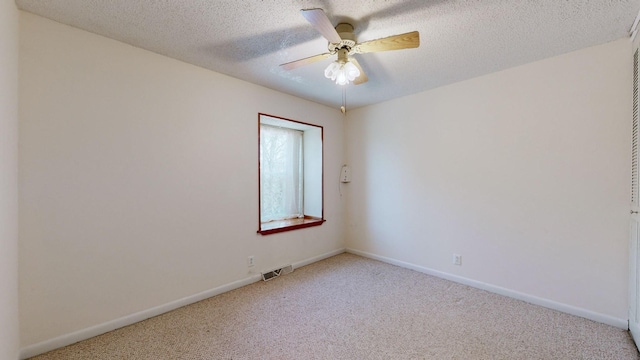 carpeted empty room featuring ceiling fan and a textured ceiling