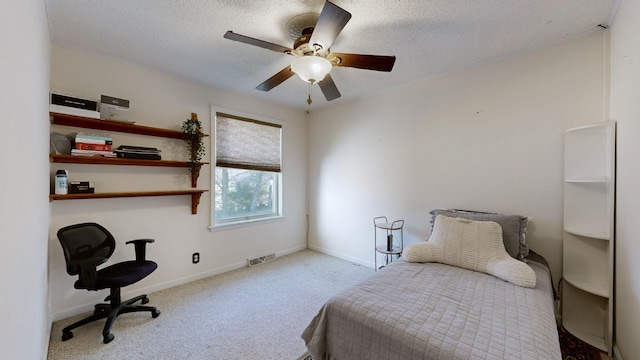 bedroom with ceiling fan, light colored carpet, and a textured ceiling