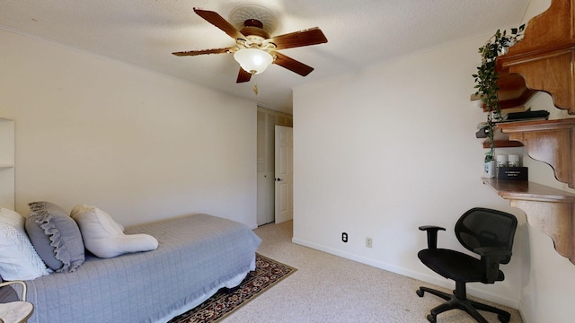 carpeted bedroom featuring ceiling fan and a textured ceiling