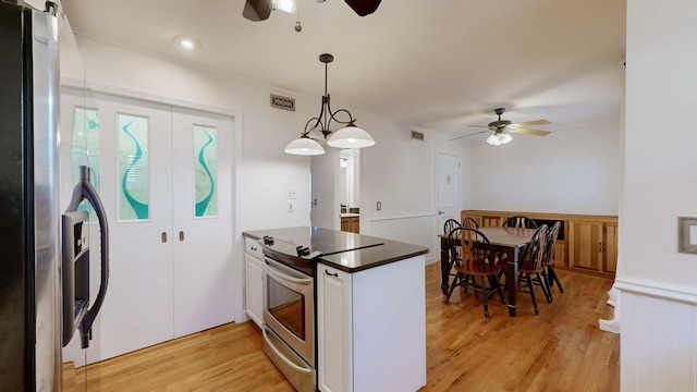 kitchen featuring light wood-type flooring, electric stove, pendant lighting, white cabinetry, and fridge