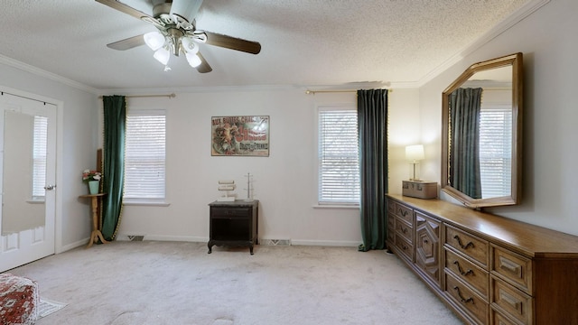 interior space with ceiling fan, crown molding, a textured ceiling, and light carpet