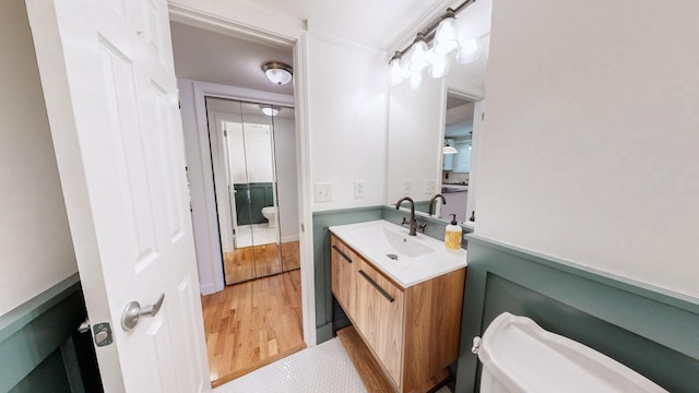 bathroom featuring wood-type flooring, vanity, and toilet