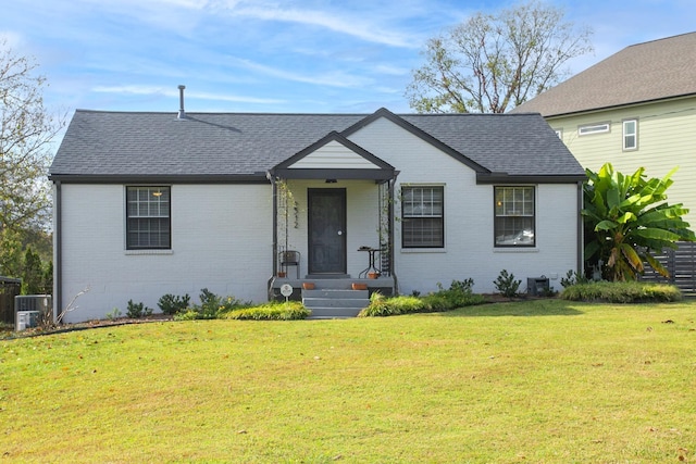 view of front of home with central AC unit and a front lawn