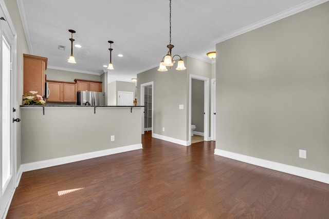 kitchen with decorative light fixtures, ornamental molding, dark wood-type flooring, and stainless steel refrigerator