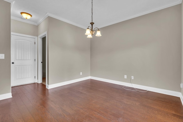 empty room with dark hardwood / wood-style flooring, ornamental molding, and a notable chandelier