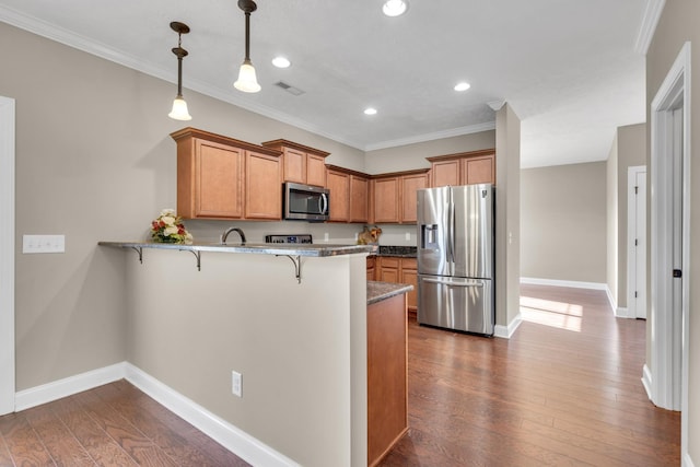 kitchen with a breakfast bar area, decorative light fixtures, appliances with stainless steel finishes, dark hardwood / wood-style floors, and kitchen peninsula