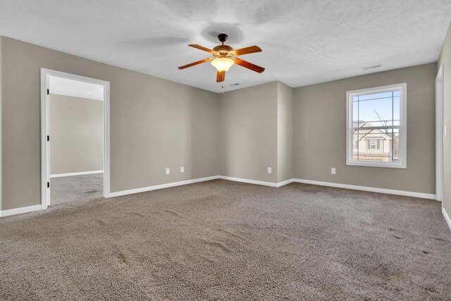 carpeted spare room featuring ceiling fan and a textured ceiling