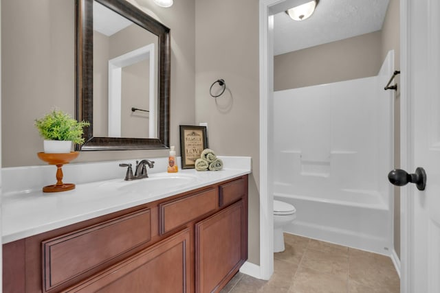 full bathroom featuring tile patterned flooring, vanity,  shower combination, toilet, and a textured ceiling