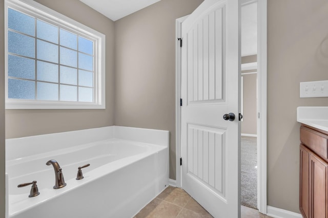 bathroom with tile patterned flooring, a bathtub, and vanity