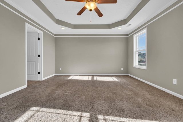 carpeted empty room featuring a tray ceiling, ceiling fan, and crown molding