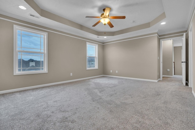 carpeted empty room featuring crown molding, a raised ceiling, and ceiling fan