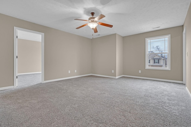 unfurnished room with ceiling fan, light carpet, and a textured ceiling