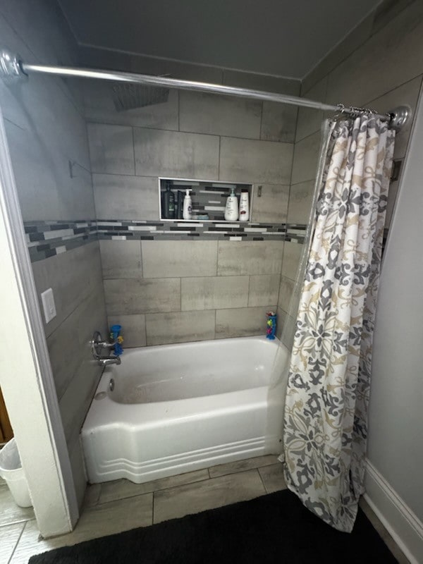 bathroom featuring shower / bath combo with shower curtain and tile patterned floors