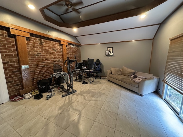 exercise room featuring vaulted ceiling, light tile patterned floors, and brick wall