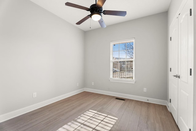 unfurnished bedroom with ceiling fan, light wood-type flooring, and a closet