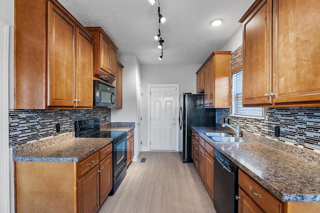 kitchen with sink, a textured ceiling, light hardwood / wood-style floors, and black appliances