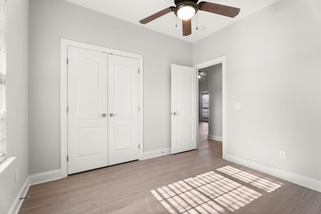 unfurnished bedroom with light hardwood / wood-style flooring, a closet, and ceiling fan