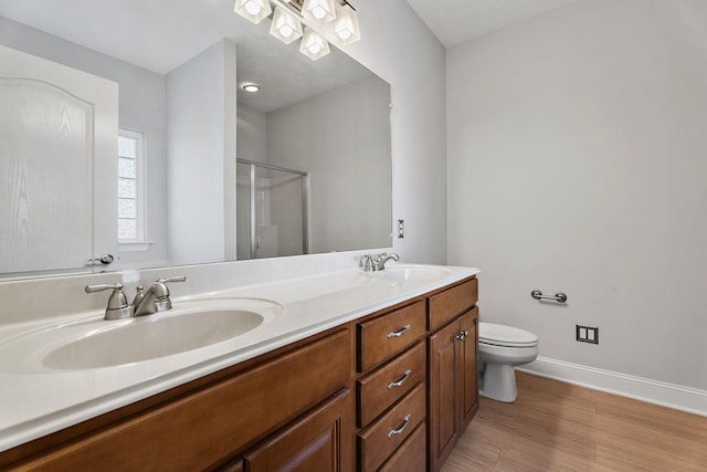 bathroom with vanity, toilet, a shower with shower door, and wood-type flooring