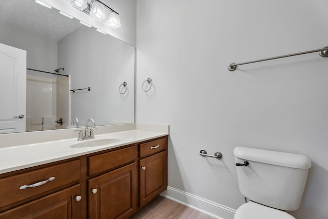 bathroom with vanity, toilet, wood-type flooring, and a shower