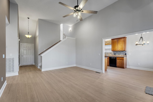 unfurnished living room featuring high vaulted ceiling, ceiling fan with notable chandelier, and light wood-type flooring