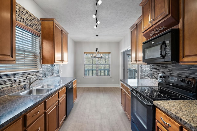 kitchen featuring sink, an inviting chandelier, black appliances, light hardwood / wood-style floors, and a textured ceiling