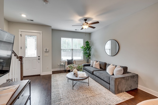 living room with dark hardwood / wood-style flooring and ceiling fan