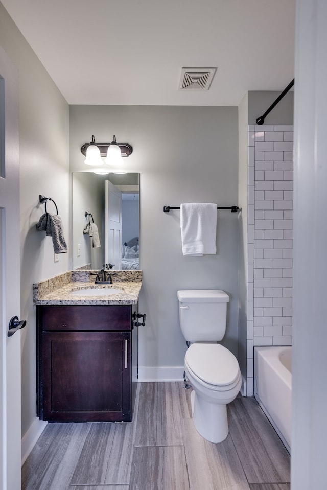 full bathroom featuring hardwood / wood-style floors, vanity, and toilet