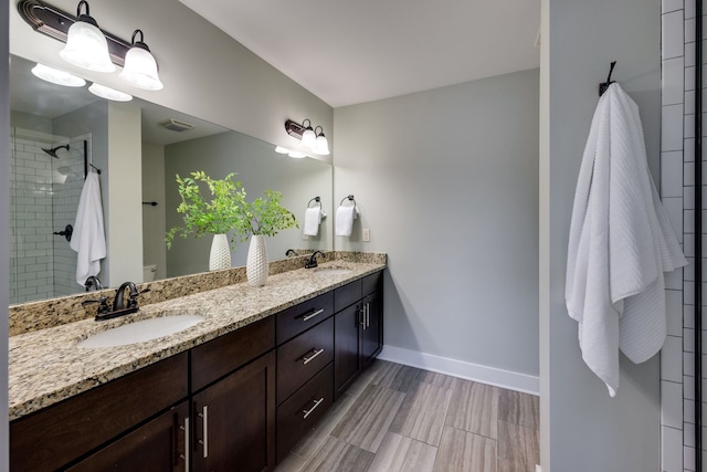 bathroom featuring a shower with shower door and vanity