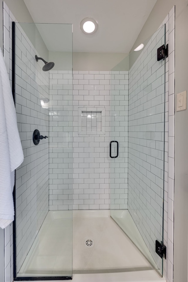 bathroom with a shower with door