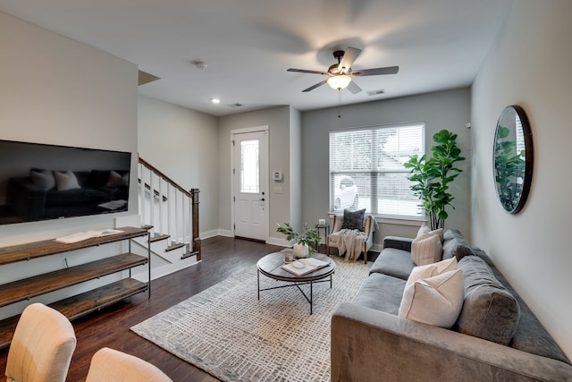 living room with dark hardwood / wood-style flooring and ceiling fan