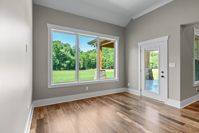 entryway featuring hardwood / wood-style floors, crown molding, and vaulted ceiling